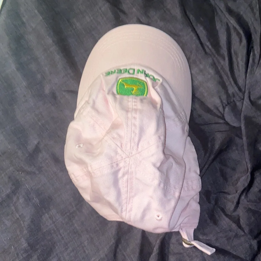 Pink John Deere hat with adjustable strap.
